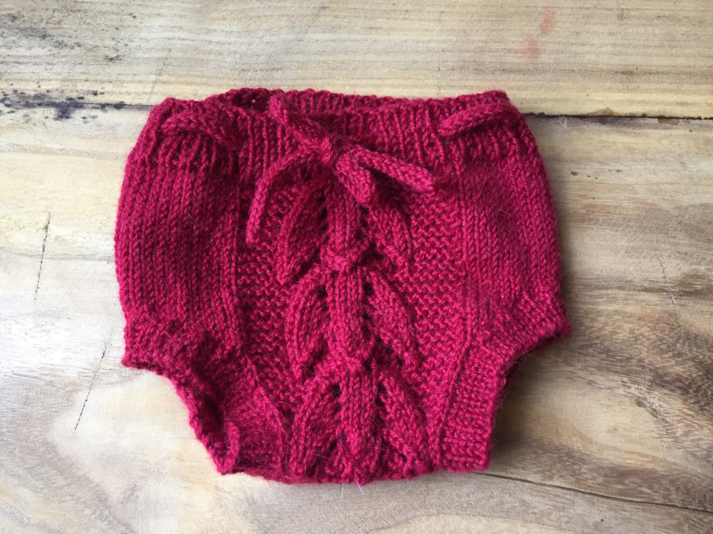 Red hand knit heirloom baby bloomers in alpaca yarn and tulip lace pattern my Anne Dresow.